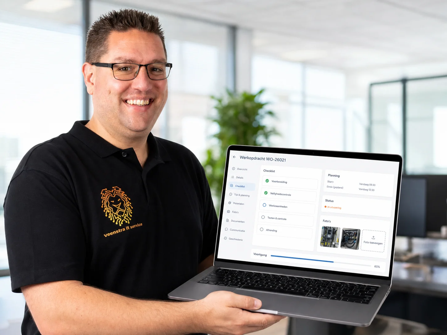 Mike Veenstra toont de werkopdrachtweergave van een zakelijke webapp op een laptop